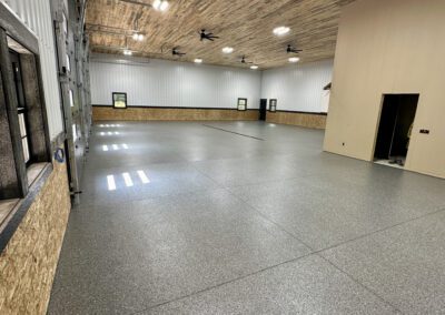 An expansive interior space with a prominent garage door and a ceiling fan, enhancing ventilation and light