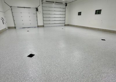 A wide expanse of concrete covers the garage floor, providing a sturdy and durable surface for various activities