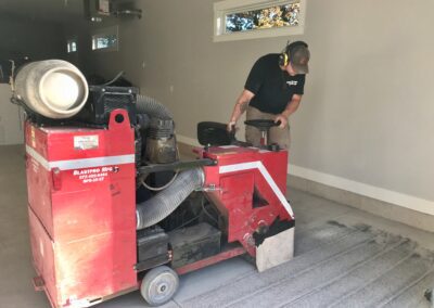 A man operates a machine to efficiently clean and organize a cluttered garage space