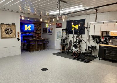 A garage featuring a bar, a television, and a bike, creating a cozy recreational space for relaxation and entertainment