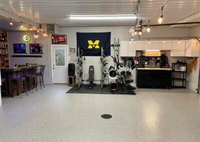 A garage featuring a bar, a television, and a bike, creating a cozy recreational space for relaxation and entertainment